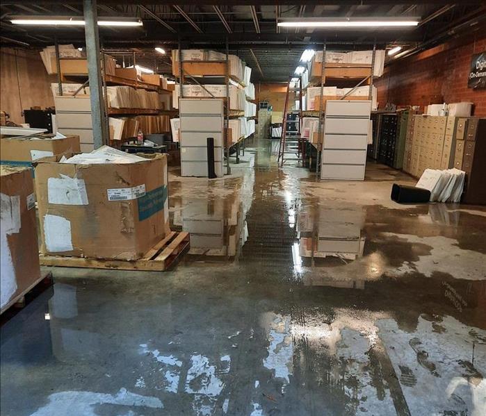 Water saturating floors and boxes in a commercial warehouse space