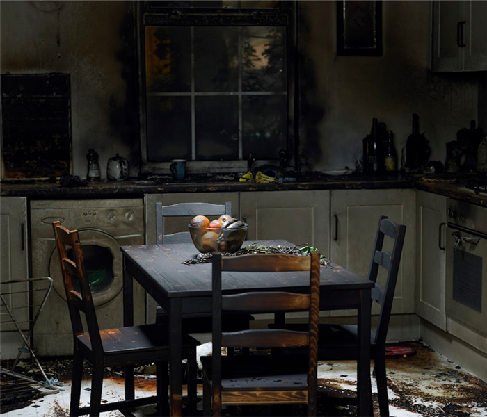 a fire damaged kitchen with soot covering the tables and counter