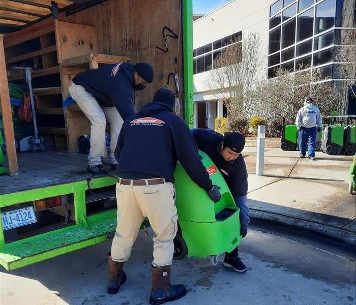 servpro techs loading van with drying equipment