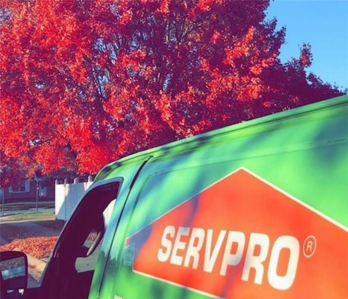 a SERVPRO truck parked on the street next to a house