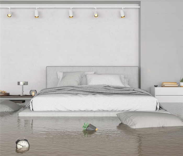 a flooded bedroom with water up to the bed and furniture floating everywhere